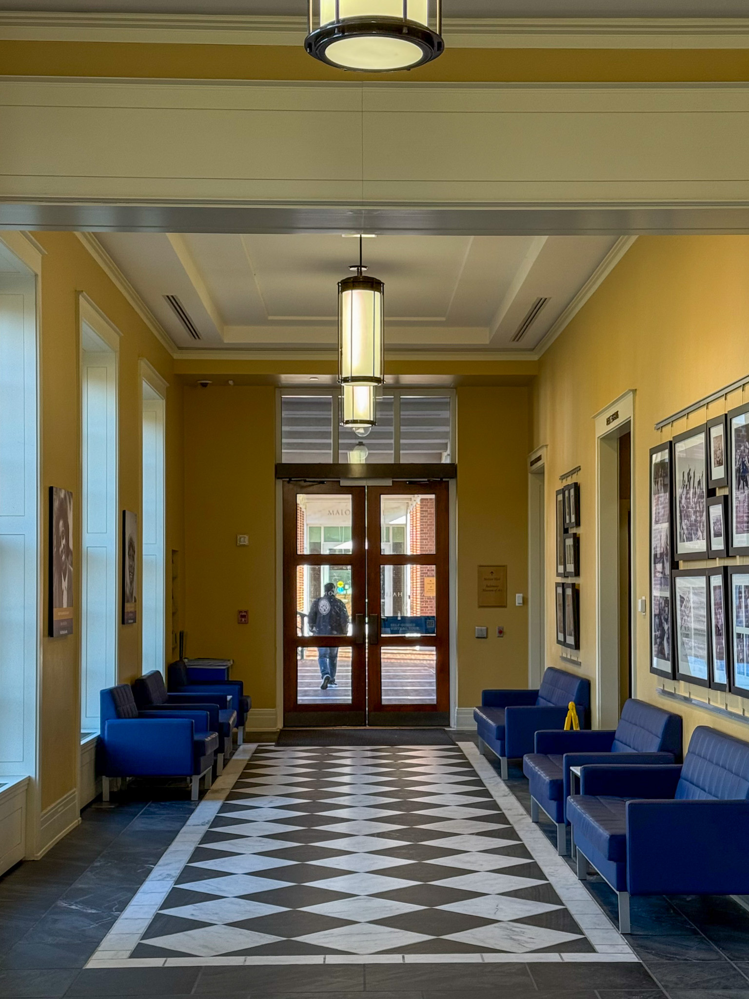 Hallway with checkered floor leading to entry door